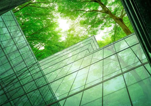 Eco-friendly building in the modern city. Sustainable glass office building with tree for reducing heat and carbon dioxide. Office building with green environment. Corporate building reduce CO2.